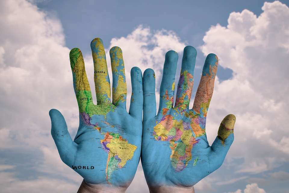 Hands with map of the world overlay.